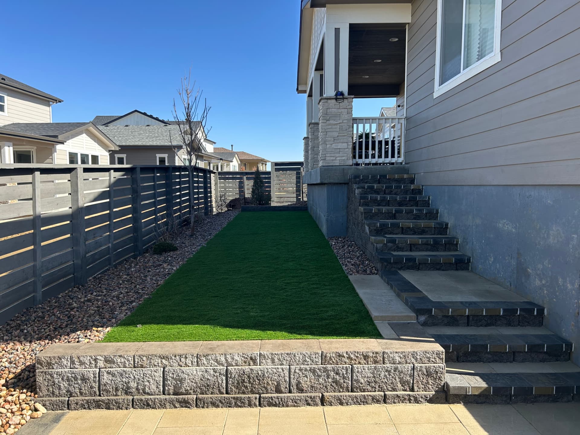 Narrow side yard with turf strip, rock border and block steps