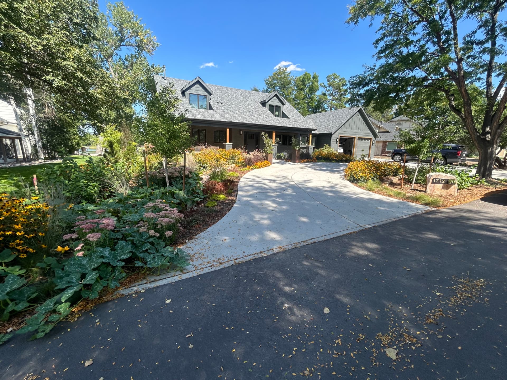 Front yard landscape installation with curved concrete drive and perennial beds in Northern Colorado